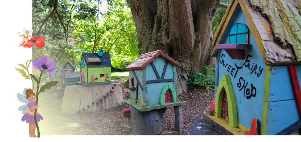 Creative, colorful miniature houses labeled "Fairy Sweet Shop" are nestled in a wooded area with lush greenery near Malahide Castle. A whimsical fairy and flowers adorn the left side, adding to the magical ambiance.