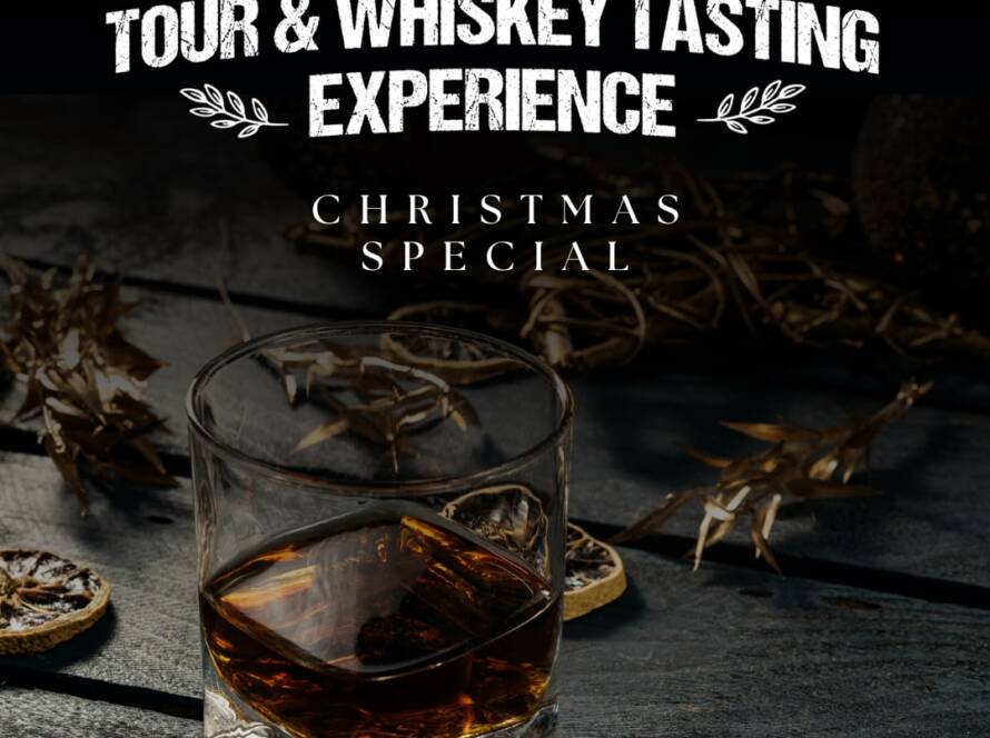 A glass of whiskey sits on a wooden table adorned with dried leaves and citrus slices. Bold white text above reads "Tour & Whiskey Tasting Experience" and "Christmas Special." The image has a dark, rustic ambiance.